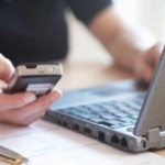 AJFBG5 Woman Telephoning While Using Online Banking